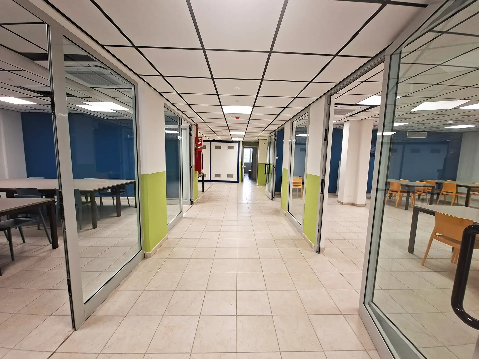 Corridoio con aule studio vetrate e tavoli da studio a Padova Campus